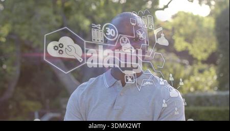 Stehender Mann mit hellgrauen Polo-Klapparmen mit holographischen sechseckigen Paneelen im Park Stockfoto