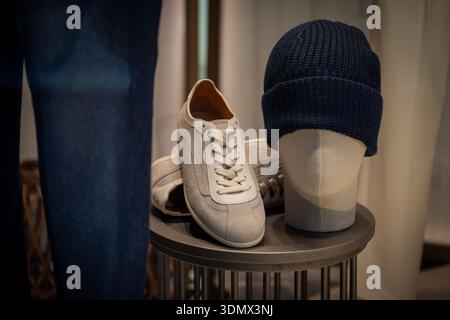 Mailand, Italien - 2026, 3. Februar: Brunello Cuccinelli FW25 Schaufenster mit luxuriösen Wildleder-Sneakern und einer marineblauen Strickmütze in einer raffinierten, modernen Boutique Stockfoto