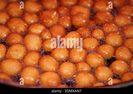 Donuts oder Donuts werden aus einer Mischung aus Mehl, Zucker, Eigelb, Hefe und Butter hergestellt. Kugelform, Puderzucker auf einem gestapelten Donut Stockfoto