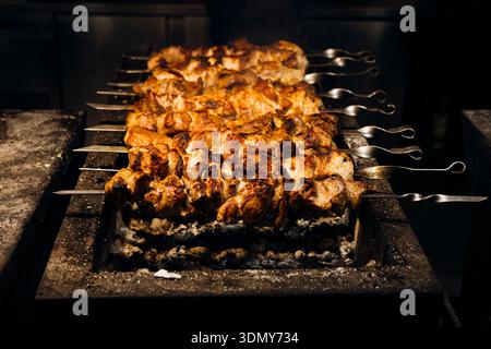 Saftige, gewürzte Fleischspieße werden auf einem belebten Street Food Market perfekt über offener Flamme gegrillt, um die Essenz authentischer Outdoor-Spezialitäten zu erfassen Stockfoto