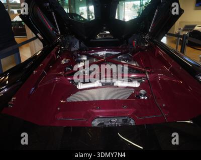 Der Motorraum des Autos zeigt komplexe Komponenten und ein elegantes Design, das fortschrittliche Technologien in einem modernen Ausstellungsraum in der Automobilbranche hervorhebt Stockfoto