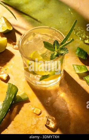 Ein herrlicher Aloe Mojito, gemischt mit frischer Minze und Limette, perfekt für eine Sommererfrischung. Dieser lebhafte Cocktail bietet eine kühlende Auszeit auf warmem Su Stockfoto