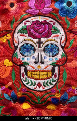 Lebendiges, gesticktes Sugar Skull-Design mit lebendigen Blumen, die mexikanische Traditionen und Handwerkskunst in Tulum widerspiegeln. Eine Feier der Kultur und Stockfoto