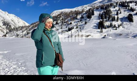 Eine ruhige Winterszene im Gasteinertal, Salzburg, Österreich, mit schneebedeckten Alpen und einer Person, die die frische Bergluft genießt. Perfe Stockfoto