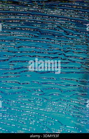 Nahaufnahme einer holografischen blauen Glasoberfläche mit geprägten, welligen Mustern. Das Bild unterstreicht die reflektierende Natur und das komplizierte Design, Captu Stockfoto