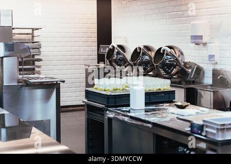 Professioneller Arbeitsbereich für Süßwaren mit Tempertrommeln und rostfreien Geräten für die Herstellung von Schokolade und Süßigkeiten Stockfoto