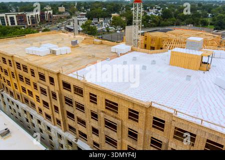 Die Arbeiter sind auf der Baustelle beschäftigt und bauen neue Gebäude in der Stadt mit Materialien auf dem Dach. Stockfoto
