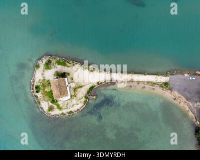 Aus der Vogelperspektive auf die historische Ypapanti-Kirche auf einer kleinen Insel in der Bucht von Kommeno, Korfu, Griechenland; eine malerische griechisch-orthodoxe Kapelle und venezianische Stockfoto