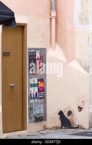 Eine Straßenszene mit Tür, Plakaten und Graffiti. Stockfoto