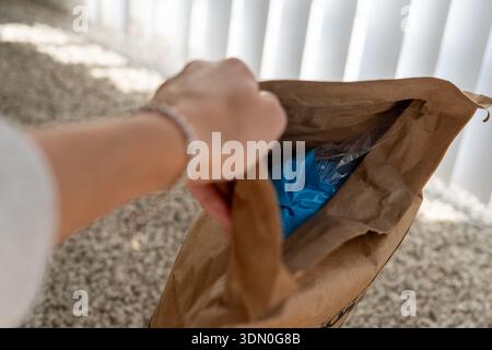 Drehen Sie mit der Hand einen Versandumschlag um, und beginnen Sie damit, das Paket in einem horizontalen Foto zu öffnen Stockfoto