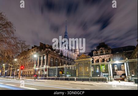 Historisches Eingangstor des Palais de Justice und der Turm der Sainte-Chapelle, beleuchtet bei Nacht auf der Ile de la Cite in Paris, Frankreich Stockfoto