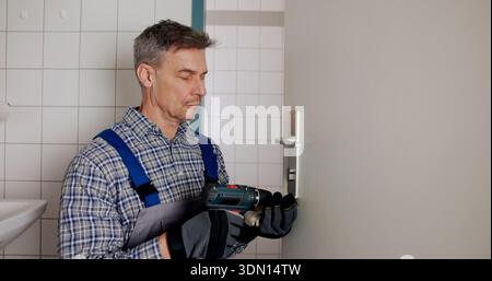 Geschulter Zimmermann, Der Ein Neues Schloss An Der Innentür Mit Präzision Installiert. Professioneller Schlosserreparaturzylinder Stockfoto