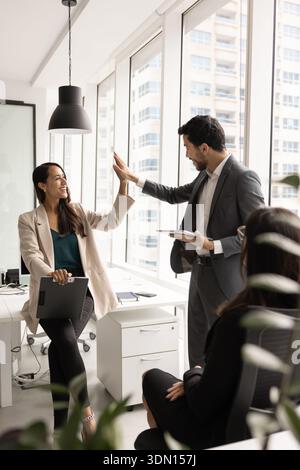 Die Teammitglieder geben sich nach erfolgreicher Teamarbeit gegenseitig fünf Stockfoto