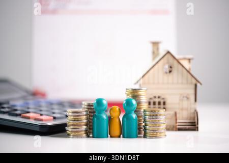 Familienhaushalt- und Hypothekenplanungskonzept für langfristigen Eigenheimbesitz und finanzielle Sicherheit, mit Münzstapeln, bunten Figuren, Kalkstein Stockfoto