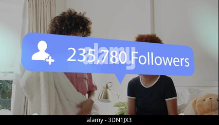 Zwei Frauen sitzen in weiße Decke gewickelt und unterhalten sich im Schlafzimmer mit blauem 235.780 Follower Overlay Stockfoto