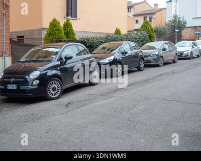 Cremona, Italien, 6. Februar 2026 Reihe von geparkten Kompaktwagen, einschließlich Fiat 500 und Citroen C3 entlang einer Wohnstraße, städtische Pendlerfahrzeuge in Stockfoto