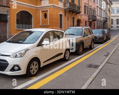 Cremona, Italien 6. Februar 2026 der weiße Hyundai i10 und der silberne Land Rover Freelander parkten dicht in einer Reihe entlang einer historischen europäischen Stadtstraße mit Stockfoto