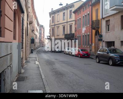 Cremona, Italien 6. Februar 2026 italienische Stadtstraße, gesäumt von alten Gebäuden und mehreren Autos, die entlang des Bürgersteigs geparkt sind, schafft ein städtisches Stadtbild Stockfoto
