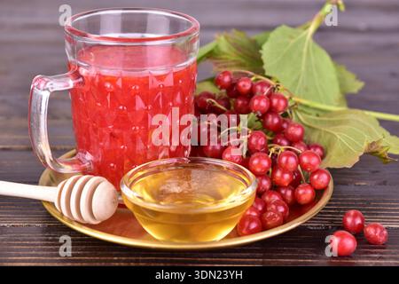 Heiltee oder Fruchtgetränk aus Viburnum-Beeren mit Honig. Stockfoto