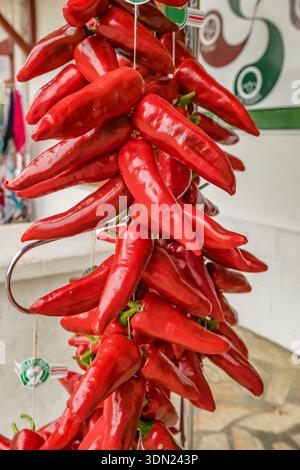 Nahaufnahme der roten Espelette-Chili-Paprika, die in Strings hängen Stockfoto