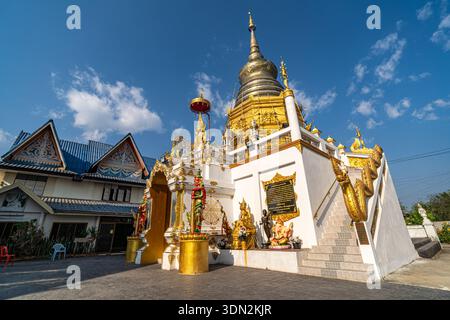 Dok kham Tai, Phayao, Thailand - 8. Februar 2026: Wat Don Chai, Ein goldener Chedi mit komplizierten Schnitzereien, flankiert von Statuen und kunstvoller Architektur Stockfoto