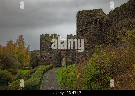 Moody graues Wetter in den Gärten vor den Türmen des Mill Gate, das durch die mittelalterlichen Stadtmauern in Conway, Nordwales führt. Stockfoto