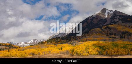 Dieses malerische Herbstpanorama bietet farbenfrohe Espenbäume, die das Gothic Valley in der Nähe von Crested Butte, Colorado, bedecken. Stockfoto
