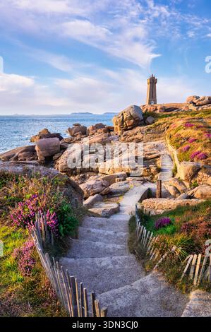 Phare de Mean Ruz an der Pink Granit Coast mit felsiger Küste und Küstenpfad in Ploumanach, Bretagne, Frankreich Stockfoto