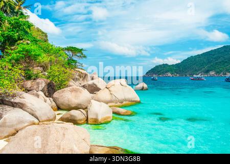Große Granitfelsen und klares türkisfarbenes Meer auf der tropischen Insel Nang Yuan, Koh Samui mit Booten und üppigen Hügeln, Thailand. Reiseziel für Stockfoto