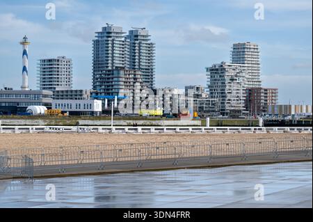 Blick auf die Promenade und den Strand mit Spaziergängern, das Meer in der Ferne und die Hochhäuser entlang der Küste von Ostend. Oostende, West-Vlaa Stockfoto