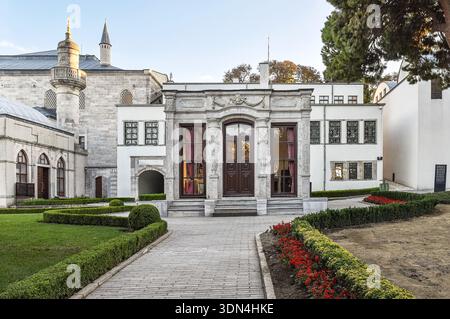 ISTANBUL, TÜRKEI - 9. Dezember 2025: Außenansicht eines historischen osmanischen Pavillons mit eleganten Marmorschnitzereien und Garten im Topkapi-Palast in Istanbul. Stockfoto