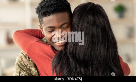 Ein Paar teilt eine freudige Umarmung zu Hause während eines Moments des Wiedersehens nach einer langen Trennung Stockfoto