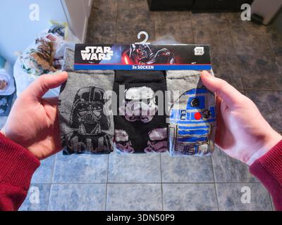 Ein Mann mit Star Wars-Socken als Weihnachtsgeschenk in England, Großbritannien. Socken mit neuem Thema decken eine Vielzahl von Themen und Interessen ab Stockfoto