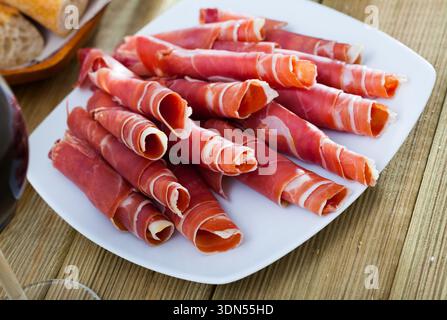 Aufgerollte Scheiben trockengehärteten Schinkens Stockfoto