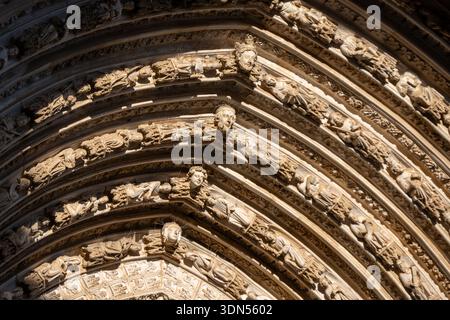 Nahaufnahme reich geschnitzter gotischer Portalbögen mit Skulpturen und dekorativem Mauerwerk in Toledo, Spanien. Stockfoto