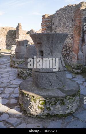 Alte Mühlsteine / Schleifsteine in der Bäckerei Popidius Priscus in Pompeji. Diese Basalt-Mühlsteine wurden in diesem Römer zum Schleifen von Getreide verwendet Stockfoto