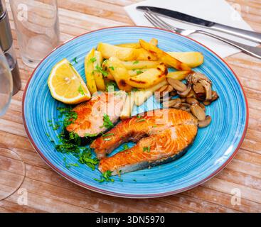 Gegrilltes Lachssteak mit Kartoffeln und Pilzen Stockfoto