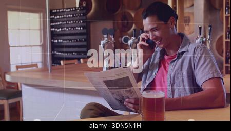 Sitzender Mann mit rotem T-Stück, Zeitung in der Hand, telefonisch in der Bar, mit Pint, Kopierraum Stockfoto