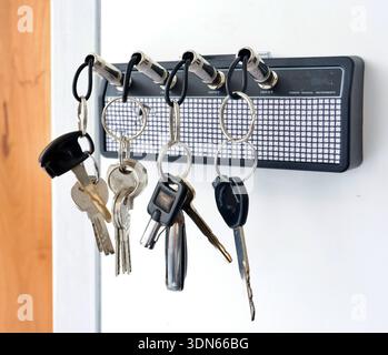 Creative Gitarrenverstärker-Schlüsselhalter mit Klinkenstecker-Schlüsselanhänger an weißer Wand Stockfoto