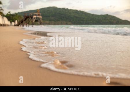 Niedriger Blick auf die Meereswellen, die an einem ruhigen tropischen Strand an Land ziehen Stockfoto