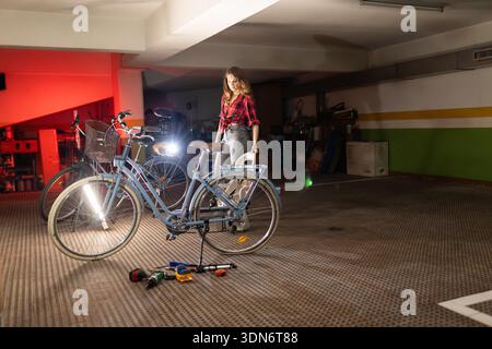 Frau repariert Fahrrad in der Werkstatt Stockfoto