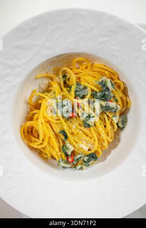 Cremige Spinatnudeln in weißer Schüssel Stockfoto