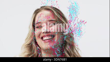 Lächelnde Erwachsene weibliche Person lacht, der Kopf neigt sich zurück im Studio, mit blauen magentafarbenen Partikeln Stockfoto