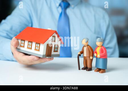 Ein pensioniertes Ehepaar beherbergt. Ein Haus an ein älteres Paar zu verkaufen. Seniorengehäuselösungen unterstützen Komfort. Immobiliendienstleistungen passen sich an Stockfoto