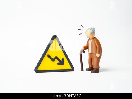 Ein älterer Mann mit einem Stock und einem nach unten zeigenden Pfeil. Rückgang der Leistungen und des Lebensstandards für ältere Menschen und Rentner. Soziale Unterhaltung Stockfoto