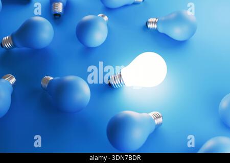Draufsicht der blauen matten Glühlampen auf blauem Hintergrund mit einer leuchtenden hellen Glühlampe. Konzept einer einzigartigen Idee, die sich von der Masse abhebt, kreativ ist Stockfoto