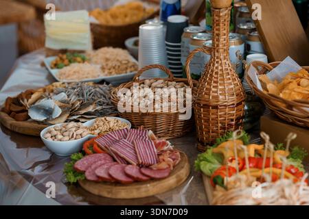 Eine lebendige, mediterrane Küche mit Räucherfleisch, frischem Käse, gerösteten Nüssen, getrocknetem Fisch und farbenfrohem Gemüse in Wove Stockfoto