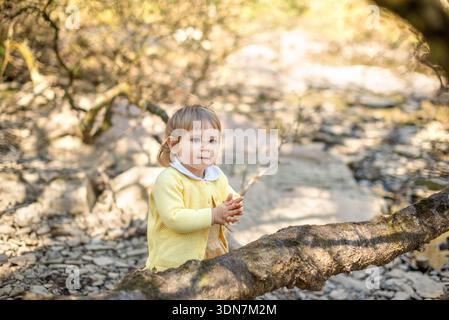 Das Kind hält die Hände zusammen, während es im Wald spielt Stockfoto