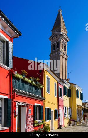 Bunte Häuser mit einem hohen Glockenturm unter einem klaren blauen Himmel an einem sonnigen Tag. Burano, Lagune Venetian, Italien Stockfoto
