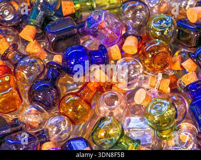 Kleine runde, bunte Glasflaschen, die mit Korkstopfen verschlossen sind Stockfoto